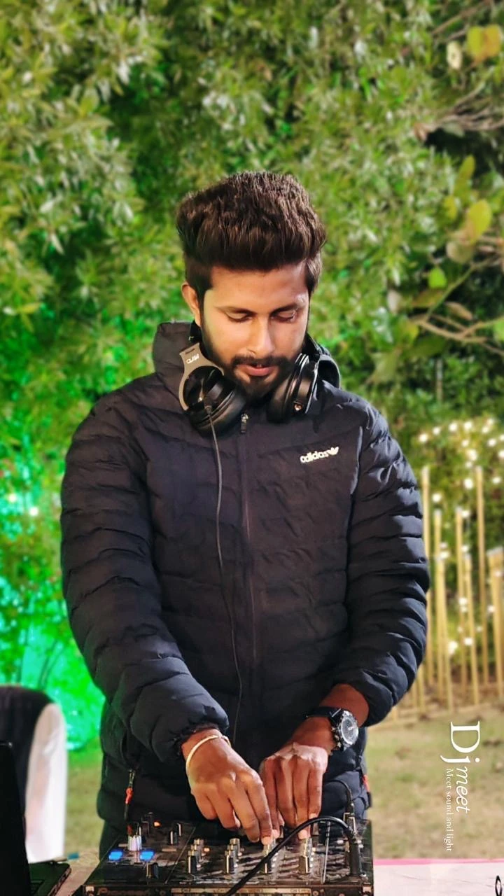 DJ Meet performing with headphones and a mixing console